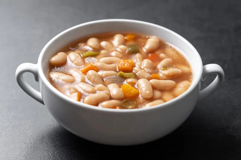 white-beans-soup-with-vegetables-white-bowl-black-background