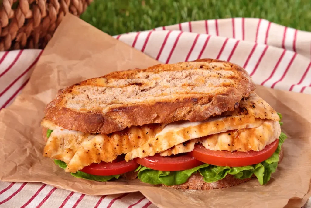 "Crispy BBQ Chicken Grilled Cheese sandwich with melted cheese, smoky BBQ chicken, and golden-brown toasted bread on a wooden plate.